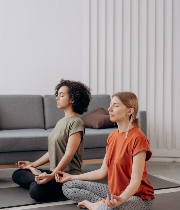 Woman in a calm yoga pose in a softly lit room.
